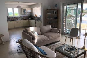 ein Wohnzimmer mit einem Sofa und einem Tisch in der Unterkunft TROPICOOL in Les Trois-Îlets
