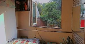 a room with a bed and a window with a view at Appna Ghar Hotel in Amritsar