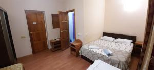a small bedroom with a bed and a mirror at Malenkaya Greсia in Anapa