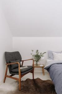 a bedroom with a chair next to a bed at Cabeca Da Cabra Casa De Campo in Porto Covo