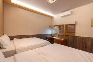 Habitación de hotel con 2 camas y escritorio en Yao Woo B&B en Dongshan