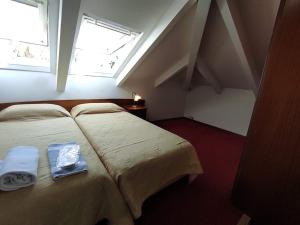 a hotel room with two beds and a window at Porto Lesvos hotel in Mytilene