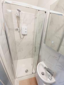 a white bathroom with a shower and a toilet at Southend on Sea - Westcliff Studios - Great Location in Southend-on-Sea