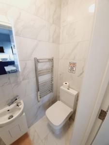 a white bathroom with a toilet and a sink at Southend on Sea - Westcliff Studios - Great Location in Southend-on-Sea