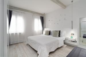 a white bedroom with a bed and a window at Dépendance Machiavelli - Apartment and Wine in Florence