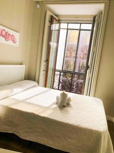 een bed met een kaars erop en een raam bij El Hostall in Madrid