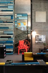 a room with a red chair and a wall of books at DUPARC Contemporary Suites in Turin