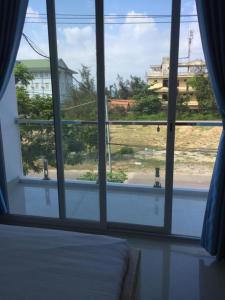 1 dormitorio con ventana y vistas a un edificio en Tuấn Anh 2 Hotel, en Dong Hoi