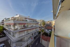 un immeuble d'appartements avec balcon dans une rue de la ville dans l'établissement SERRENDY Cannes Palm Beach 2min walk to beaches, à Cannes
