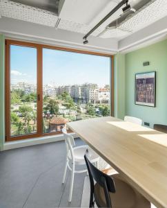 una oficina con una mesa grande, sillas y una ventana grande en Zeus is Loose Hostel en Tesalónica