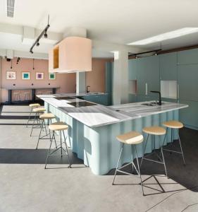 a kitchen with a blue counter and stools at Zeus is Loose Hostel in Thessaloniki