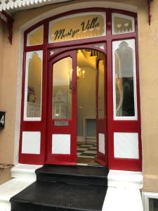 a red door on the front of a store at Mostyn Villa in Llandudno