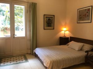 a bedroom with a bed and a door with a window at Rothschild Tel-Aviv Studio in Tel Aviv