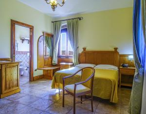 - une chambre avec un lit et une chaise dans l'établissement Relais Il Mulino, à Corigliano Calabro