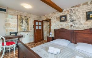 a bedroom with a wooden bed and a desk and a desk at House Peresiji in Peresiji +65 photos