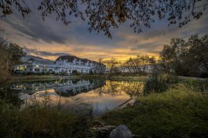 um pôr-do-sol sobre um rio com casas e aomínio em Prestige Harbourfront Resort, WorldHotels Luxury em Salmon Arm