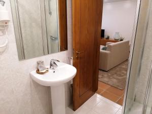 a bathroom with a sink and a shower and a mirror at Quinta da Eira do Sol in Guimarães