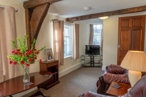 a living room with a vase of flowers on a table at Highgate View Apartment in Kendal