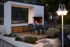 a patio with a table and chairs and a fireplace at Villa Sena in Ražanj