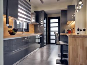 a kitchen with black cabinets and a bar with a chair at Blue View Villa in Alikanas