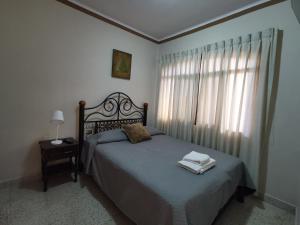Un dormitorio con una cama y una ventana con toallas. en departamento céntrico y confortable, en Tarija
