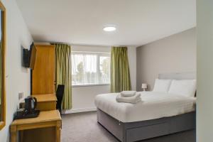 a hotel room with a bed and a window at OYO Dayz Away Lodge in Dudley