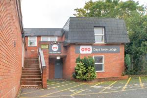 a red brick building with a dog paw alley lodge at OYO Dayz Away Lodge in Dudley
