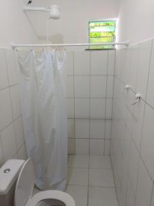 a bathroom with a toilet with a shower curtain at Residencial Mar Da Galileia in Porto Seguro +44 photos