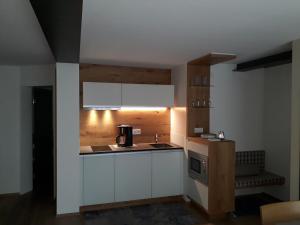 una cucina con armadietti bianchi e macchinetta del caffè di Apartment am Kniebach a Immenstaad am Bodensee