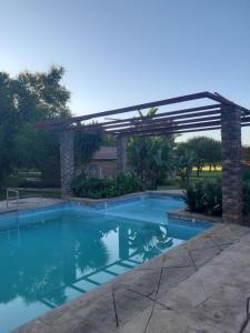 a pergola over a swimming pool in a yard at El Rancho Grande in Warmbaths