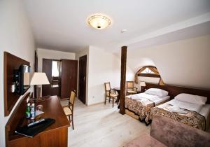 um quarto de hotel com duas camas e uma secretária com um computador em Dwór Niemierzyce em Granowo