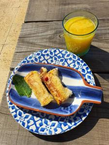 um prato azul e branco com comida e um copo de sumo de laranja em Quinta Luz do Sol em Moncarapacho