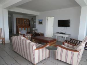 a living room with couches and a table and a television at 87 Marine Drive in Struisbaai