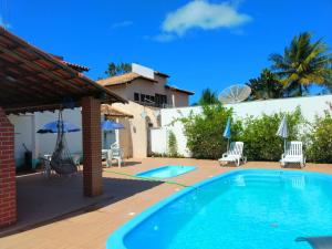 a swimming pool in the backyard of a house at Residencial Mar Da Galileia in Porto Seguro