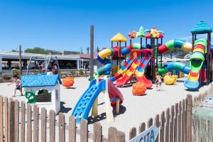 a playground in the sand with children playing on it at Cesenatico Camping Village in Cesenatico