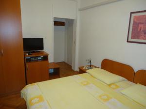 a hotel room with two beds and a flat screen tv at Peric Rooms Dubrovnik in Dubrovnik