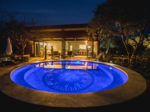 a large swimming pool in a yard at night at Aerotel in Hoedspruit