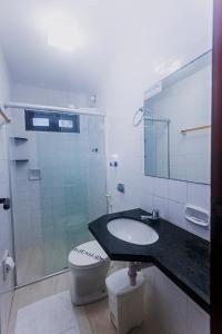 a bathroom with a sink and a toilet and a shower at Alimar Hotel in Natal