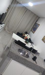 a living room with a couch and a table with flowers at Flat Paiva Home Stay in Recife