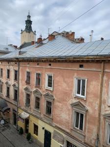 stary ceglany budynek z wieżą zegarową na górze w obiekcie Апартаменти на площі Ринок w Lwowie