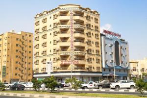 Al Farhan Hotel Suites Al siteen في الجبيل: مبنى طويل وبه سيارات متوقفة أمامه