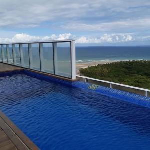 a swimming pool on top of a building overlooking the ocean at Flat Paiva Home Stay in Recife