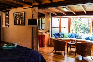 ein Schlafzimmer mit einem Bett und ein Wohnzimmer in der Unterkunft Tomah Retreat - Studio RELAX with fireplace in Mount Tomah