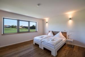 a bedroom with a bed and a large window at Design Ferienhaus 195qm in Breitbrunn am Chiemsee