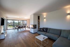 ein Wohnzimmer mit einem Sofa, einem TV und einem Tisch in der Unterkunft Design Ferienhaus 195qm in Breitbrunn am Chiemsee