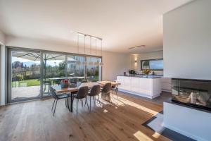 基姆湖畔布賴特布倫的住宿－Design Ferienhaus 195qm，厨房以及带桌椅的用餐室。