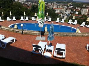 a group of chairs and umbrellas next to a pool at Park Hotel Stratesh in Lovech
