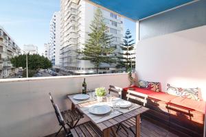un tavolo e sedie su un balcone con finestra di Modern Apartment by the Sea a Quarteira