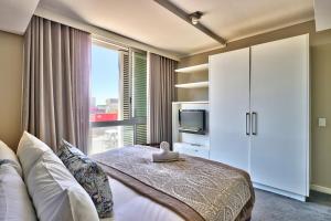 a bedroom with a bed and a large window at Harbour Bridge 13A in Cape Town