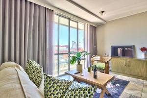 a living room with a couch and a tv at Harbour Bridge 13A in Cape Town